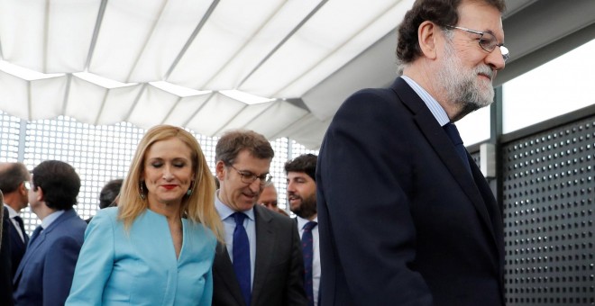 La presidenta de la Comunidad de Madrid, Cristina Cifuentes, tras el jefe del Gobierno y líder del PP, Mariano Rajoy, y junto al presidente de la Xunta de Galicia, Alberto Núñez Feijóo, tras posar para la foto de familia de los barones del PP, en la sede