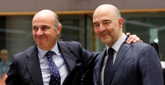 El ministro de Economía, Luis de Guindos, saluda al comisario de Economía y Asuntos Financieros, Pierre Moscovici, antes de la reunión del Ecofin. EFE/ Olivier Hoslet