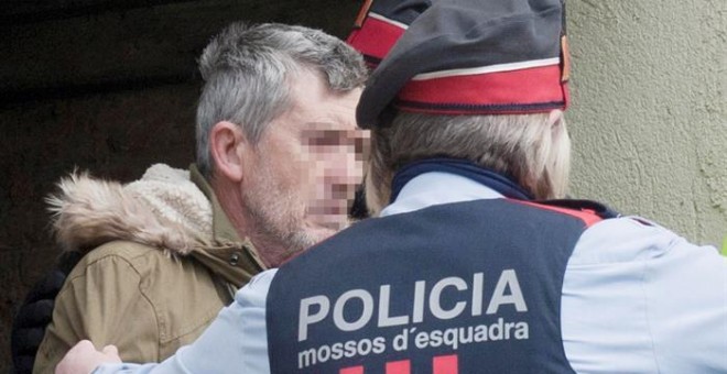 El presunto autor del doble homicidio de Susqueda, Jordi Magentí (i), acompañado de los mosos d'esquadra en el momento de acceder a una casa de Anglès. /EFE