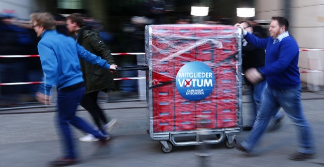 Los trabajadores del SPD llevan una carretilla con los votos de los militantes en la consulta sobre la repetición de la gran coalición con la CDU de Angela Merkel. REUTERS/Hannibal Hanschke