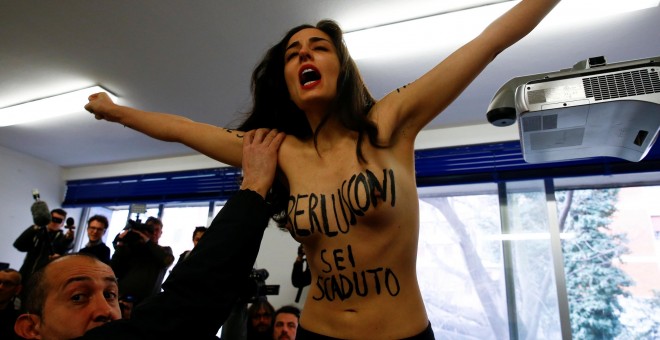 Activista de Femen protesta en Italia cuando Silvio Berlusconi se disponía a votar./ Reuters