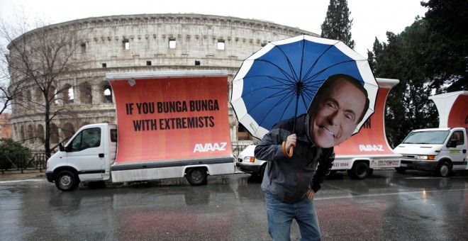 Un activista con una careta de Silvio Berlusconi. - REUTERS