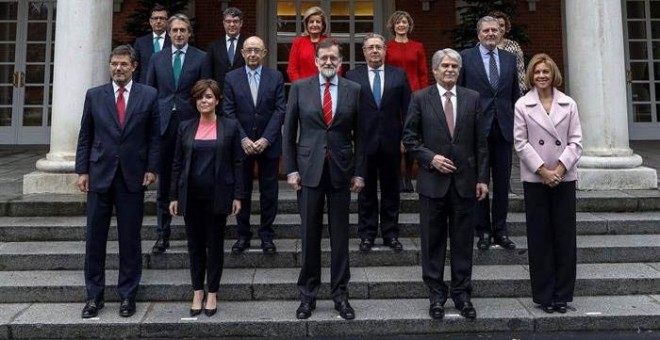 El jefe del ejecutivo, Mariano Rajoy, durante la foto oficial de su nuevo Ejecutivo tras la incorporación de Román Escolano, arriba a la izquierda. | EMILIO NARANJO (EFE)
