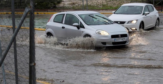 Vehículos circulando por una rotonda anegada en Espartinas (Sevilla). - EFE