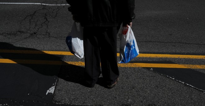 Un pensionista con dos bolsas de la compra en el centro de Madrid. REUTERS/Susana Vera
