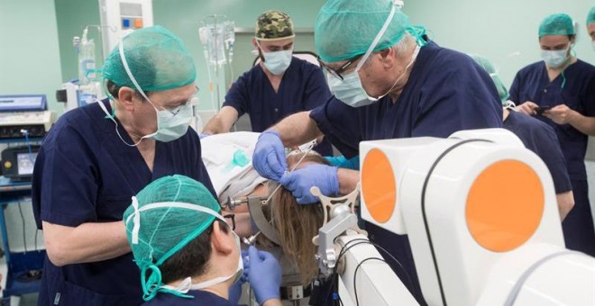 Neurocirujanos operan con un robot a la enferma de párkinson. / MARTA PÉREZ (EFE)