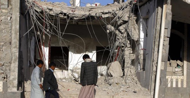 Una familia yemení frente a los escombros de un edificio presuntamente destruido por los recientes ataques aéreos, en el tercer aniversario de la campaña militar encabezada por Arabia Saudita. EFE/EPA/YAHYA ARHAB