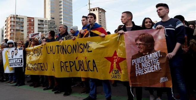 Varias personas sostienen una pancarta durante la concentración que miembros de los Comités de Defensa de la República (CDR) llevan a cabo en los exteriores de la Estación de Sants de Barcelona, donde se ha desplegado un dispositivo de los Mossos d'Esqua