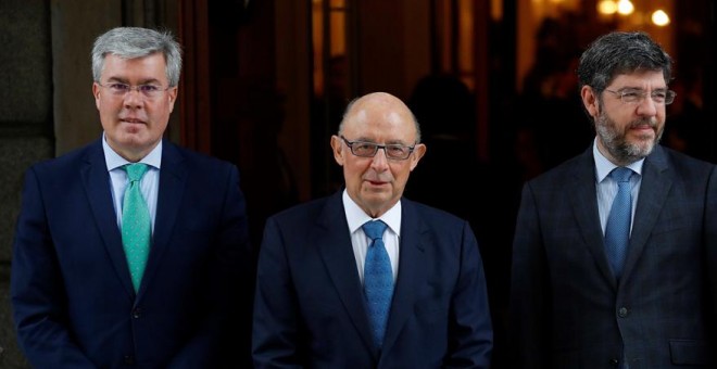 El ministro de Hacienda, Cristóbal Montoro (c), acompañado por acompañado por los secretarios de Estado de Presupuestos y Gastos, Alberto Nadal (d), y de Hacienda, José Enrique Fernández Moya (i), a su llegada al Congreso de los Diputados para presentar e