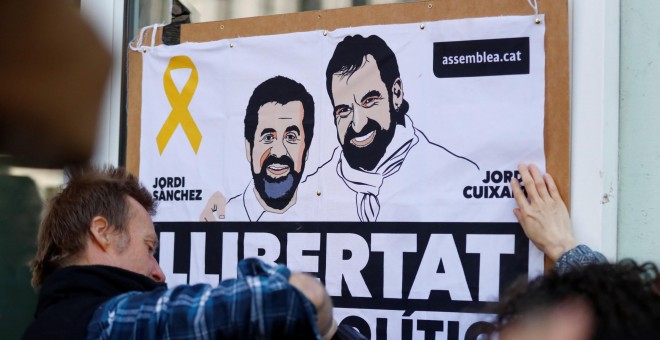 Un simpatizante de Carles Puigdemont con un cartel de apoyo a 'los Jordis' (Jordi Sánchez y Jordi Cuixart), antes de la rueda de prensa del expresident catalán en Berlín, tras su salida de una prisión alemana. REUTERS/Hannibal Hanschke