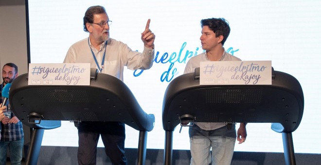 El presidente del Gobierno, Mariano Rajoy, y el presidente de Nuevas Generaciones, Diego Gago, conversan mientras caminan en una cinta de correr en la jornada del sábado de la Convención Nacional del PP en Sevilla. EFE/Julio Muñoz