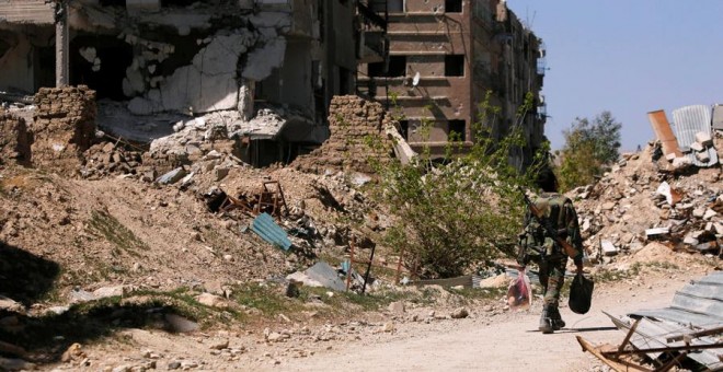 Un soldado camina por unas ruinas en Guta. REUTERS/Omar Sanadiki