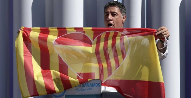 El presidente del PP catalán, Xavier García Albiol, porta en Badalona una bandera con los colores de la senyera y la enseña rojigualda. EFE/Archivo