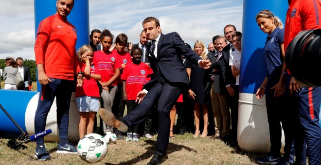 El presidente francés Emanuel Macron golpea a un balón en su visita a un centro de recreo para menores en la localidad de Moisson. REUTERS/Philippe Wojazer