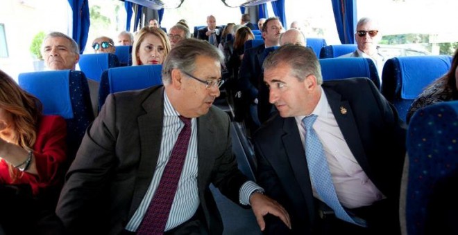 Fotografía facilitada por el Ministerio del Interior del titular del Departamento, Juan Ignacio Zoido (i), conversando con Miguel Folguera, de la asociación Plataforma de apoyo a las víctimas, en el autocar que traslada a los representantes de asociacione