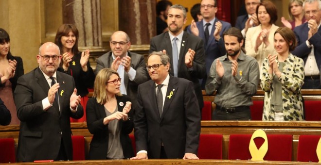 Quim Torra, al costat d'Elsa Artadi i Eduard Pujol, rep els aplaudiments dels diputats de JxCat, després de ser investit com a nou president de la Generalitat. / Parlament de Catalunya