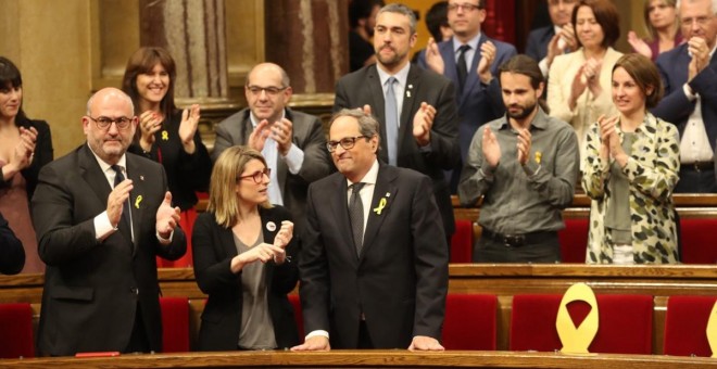 Quim Torra, al costat d'Elsa Artadi i Eduard Pujol, rep els aplaudiments dels diputats de JxCat, després de ser investit com a nou president de la Generalitat. / Parlament de Catalunya