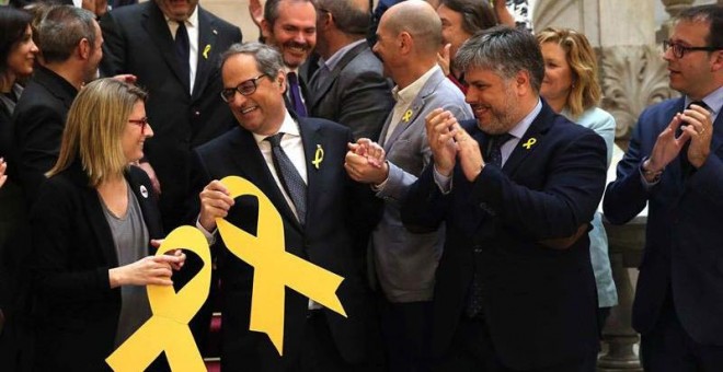 El nuevo presidente de la Generalitat, Quim Torra (c), aplaudido por los miembros de su partido en la escalinata del Parlament (TONI ALBIR | EFE).