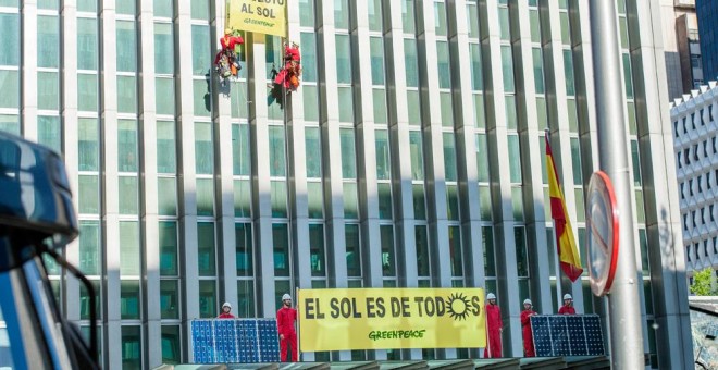 Activistas de Greenpeace subiendo una placa solar por la fachada del Ministerio. GREENPEACE