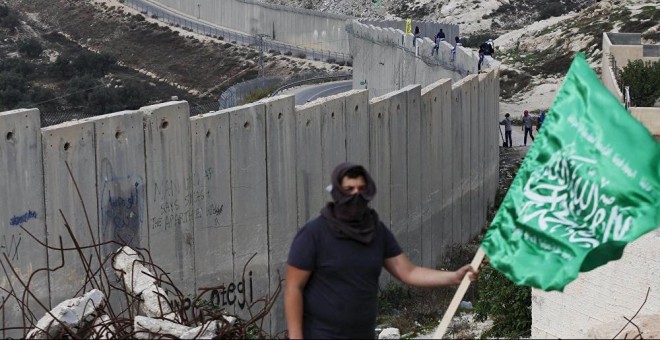 Joven palestino sujeta una bandera de Hamás - REUTERS