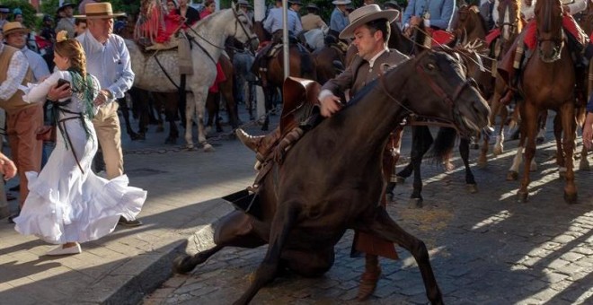 Un caballo se cae durante la salida en la Plaza del Salvador de la Hermandad de Sevilla. - EFE