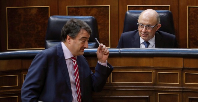 El ministro de Hacienda, Cristóbal Montoro, conversa con el portavoz del PNV, Aitor Esteban, durante el Pleno del Congreso que vota la totalidad del proyecto de Ley de Presupuestos Generales del Estado de 2018. EFE/Emilio Naranjo