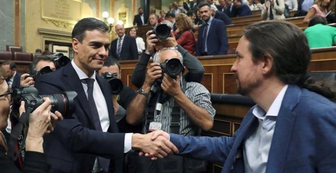 El secretario general del PSOE Pedro Sánchez, saluda al líder de Podemos Pablo Iglesias, en el hemiciclo del Congreso tras el debate de la moción de censura. /EFE