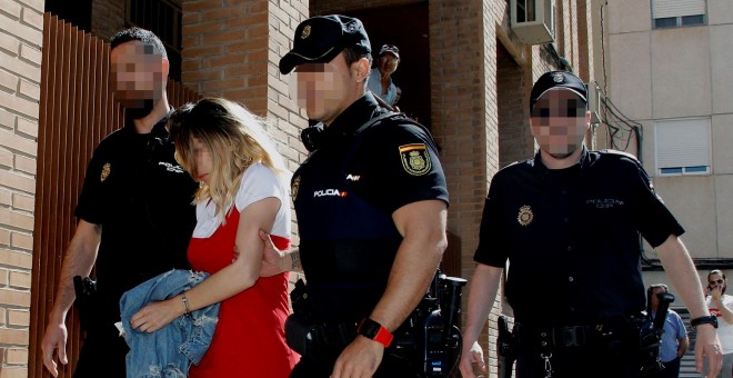 La mujer detenida como presunta autora del asesinato del hijo de acogida de su pareja sentimental sale tras el registro de un domicilio acompañada de agentes de la Policía Nacional. EFE/MORELL