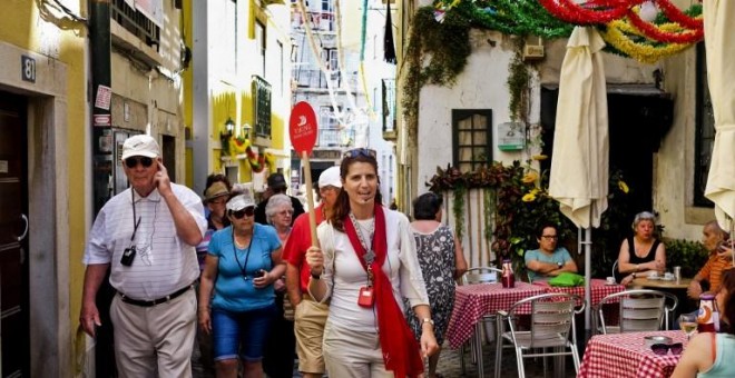 Guía turística dirige a unos turistas por las calles de Lisboa AFP / PATRICIA DE MELO MOREIRA