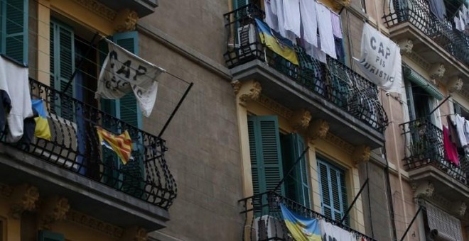 Pancartas que dicen 'No a los apartamentos turísticos' cuelgan de un balcón para protestar contra los pisos para turistas en Barcelona. AFP
