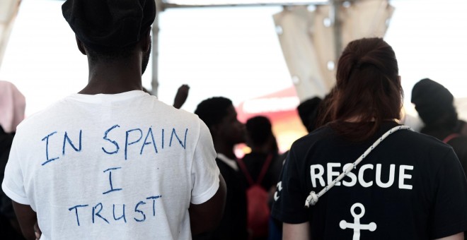 Un migrante con una camiseta en la que ha escrito, en inglés, 'En España confío', espera a desembarcar del buque Aquarius en el puerto de Valencia. REUTERS /Kenny Karpov/SOS Mediterranee
