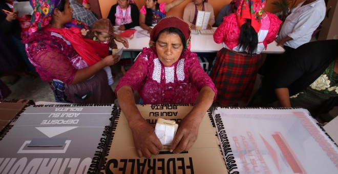Una mujer deposita su voto en una colegio electoral de San Bartolomé de Quialana, México.- REUTERS/Jorge Luis Plata