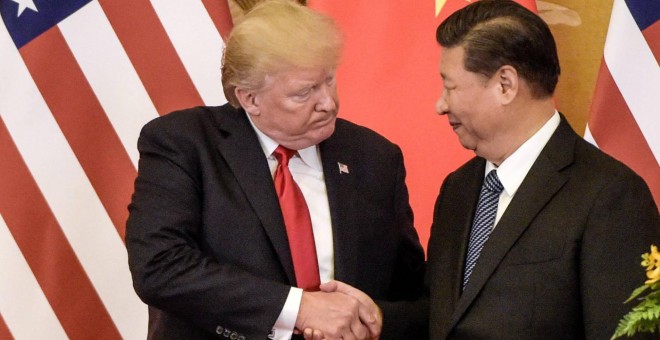 Donald Trump, a la izquierda, estrechando la mano del líder chino, Xi Jinping - FRED DUFOUR/AFP