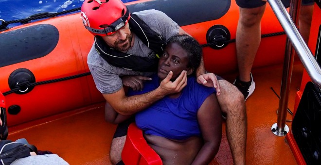 Un miembro de Open Arms rescata a un mujer, en estado de 'shock', en el Mediterráneo. REUTERS