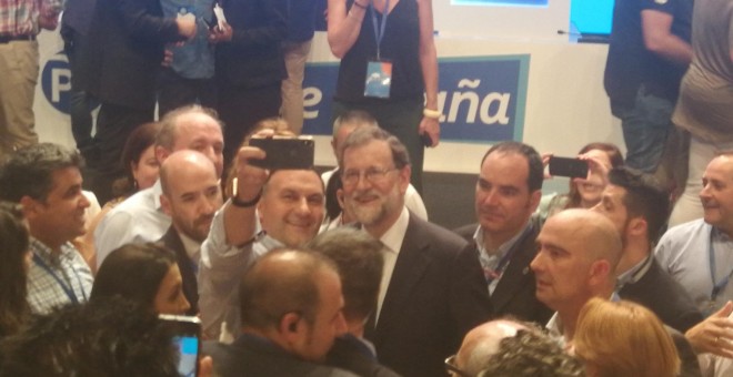 Rajoy se marcha del plenario haciéndose fotos con afiliados y seguidores./PÚBLICO