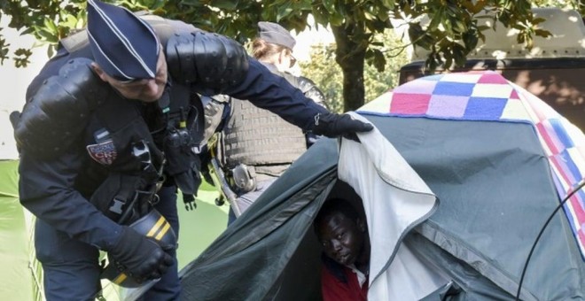 Un agente de policía durante el desalojo de cientos de personas migrantes acampadas en la ciudad de Nantes.- AFP/ SALON GOMIS