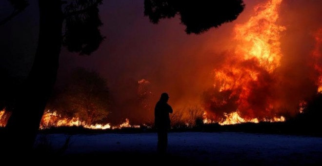 Un hombre observa las llamas en la ciudad de Rafina, cerca de Atenas.(COSTAS BALTAS | EFE)