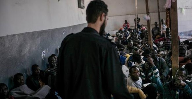 Un militar libio custodia a cientos de personas encerradas en una centro de detención de inmigrantes de Libia-. MSF