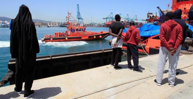 Varios migrantes observan la llegada de una embarcación de Salvamento Marítimo con 19 migrantes rescatados en el estrecho de Gibraltar. EFE/A. Carrasco Ragel