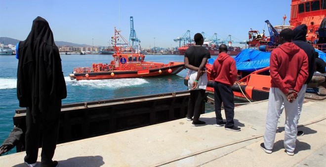 Varios migrantes observan la llegada de una embarcación de Salvamento Marítimo con 19 migrantes rescatados en el estrecho de Gibraltar. EFE/A. Carrasco Ragel