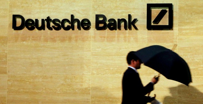 Un hombre com paraguas pasa frente a las oficinas de  Deutsche Bank en Londres. REUTERS/Luke MacGregor