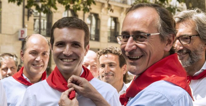 El presidente del PP del País Vasco, Alfonso Alonso, pone al presidente de los populares, Pablo Casado, el pañuelo festivo durante la visita de ésta a Vitoria. EFE