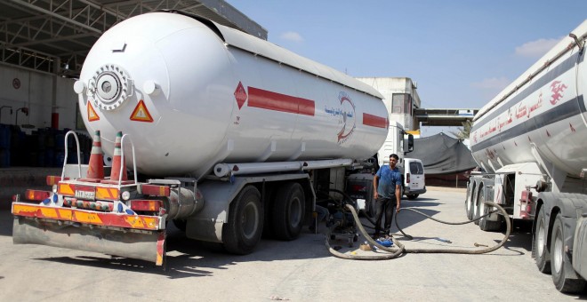 Un trabajador palestino llena un petrolero con gas de cocina importado de Egipto, en Rafah, al sur de la Franja de Gaza. / Reuters