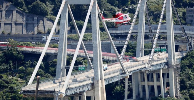 Un helicóptero de los bomberos sobrevuela la zona del puente Morandi, que se desplomó el pasado martes. REUTERS/Stefano Rellandini