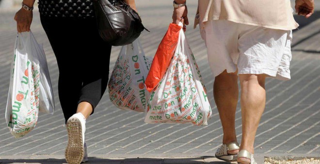 Dos mujeres llevan varias bolsas de plástico/EFE