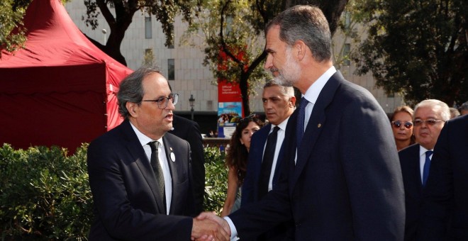 El rey Felipe VI saluda al presidente de la Generalitat, Quim Torra, a su llegada a la plaza de Catalunya para presidir los actos de homenaje a las víctimas en el primer aniversario de los atentados del 17 de agosto en Barcelona y Cambrils. EFE/Casa de S.