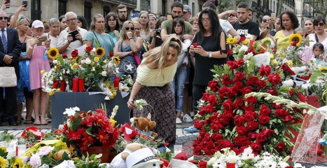 Grupo de personas depositan flores en el mosaico de Miró en Las Ramblas en recuerdo de las victimas de los atentados del 17-A. - EFE