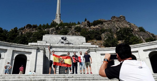 Un grupo de personas con una bandera anticonstitucional y otra de la Falange se fotografía en la explanada del Valle de los Caídos.EFE/Mariscal