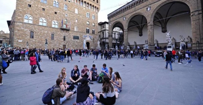 Un grupo de turistas comen en la plaza de la Señoría de Florencia. REUTERS/Archivo