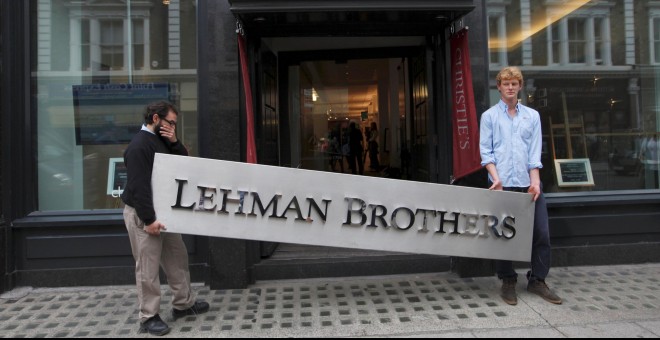 Dos empleados sujetan el letrero de la empresa Lehman Brothers. REUTERS/Andrew Winning